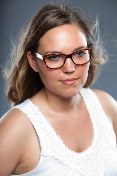 Pretty woman with long brown hair wearing glasses. Fashion studio shot isolated on grey background. — Stock Photo, Image