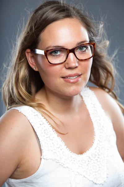 Mulher bonita com cabelo castanho longo usando óculos. Estúdio de moda tiro isolado em fundo cinza . — Fotografia de Stock