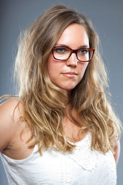 Mujer bonita con el pelo largo y castaño usando gafas. Estudio de moda filmado aislado sobre fondo gris . —  Fotos de Stock