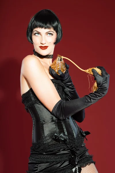 Burlesque Pin-up Frau mit schwarzen Haaren in schwarz gekleidet. sexy Pose. Studio-Mode aufgenommen isoliert auf rotem Hintergrund. — Stockfoto