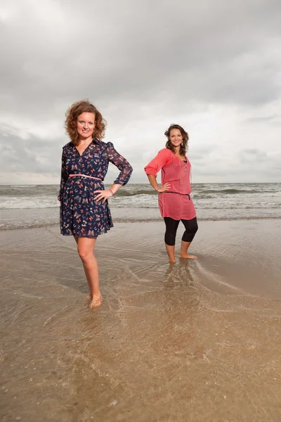 Dwa szczęśliwy dziewczyny świeżym z przyrodą w pobliżu plaży. czerwone i brązowe włosy. pochmurnego nieba. — Zdjęcie stockowe