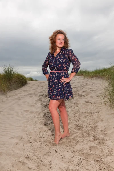 Glad tjej som njuter av utomhus natur nära stranden. rött hår. molnig himmel. — Stockfoto