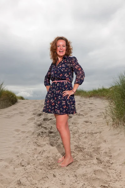 Счастливая девушка, наслаждающаяся природой рядом с пляжем. Рыжие волосы. Облачное небо . — стоковое фото