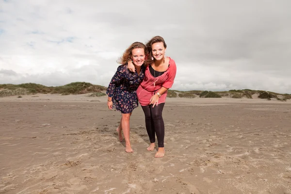 Twee gelukkige meisjes genieten van buiten natuur in de buurt van het strand. rode en bruine haren. bewolkte hemel. — Stockfoto
