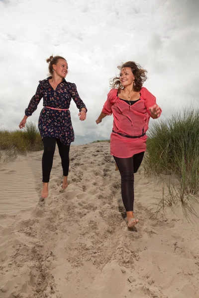 Deux filles heureuses profitant de la nature extérieure près de la plage. Cheveux roux et bruns. Ciel nuageux . — Photo