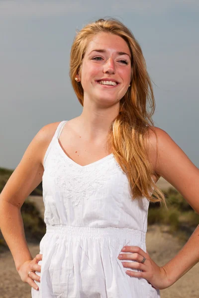 Chica bonita con el pelo largo rojo con vestido blanco disfrutando de la naturaleza cerca de la playa. Día caluroso de verano con cielo azul nublado . —  Fotos de Stock
