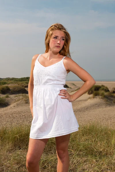 身穿白色礼服享受大自然在海滩附近的红色长头发的漂亮女孩。炎热的夏天天与蓝多云的天空. — 图库照片