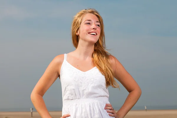Plaja yakın doğanın keyfini beyaz elbise kırmızı uzun saçlı güzel bir kız. sıcak yaz günü bulutlu gökyüzü mavi. — Stok fotoğraf