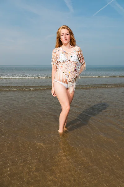 Bella ragazza con i capelli lunghi rossi che indossa bikini bianco godendo all'aperto in spiaggia. Caldo giorno d'estate con cielo nuvoloso blu . — Foto Stock