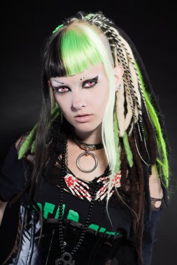 Cyber punk kız yeşil sarı saçları ve siyah arka plan üzerine izole kırmızı gözleri. etkileyici bir yüz. Stüdyo vurdu.