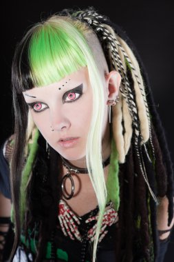 Cyber punk kız yeşil sarı saçları ve siyah arka plan üzerine izole kırmızı gözleri. etkileyici bir yüz. Stüdyo vurdu.