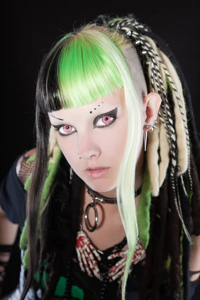Cyber punk girl aux cheveux blonds verts et aux yeux rouges isolés sur fond noir. Visage expressif. Plan studio . — Photo