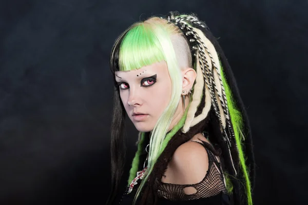 Cyber punk pige med grøn blond hår og røde øjne isoleret på sort baggrund. Udtryksfuldt ansigt. Studieoptagelse . - Stock-foto