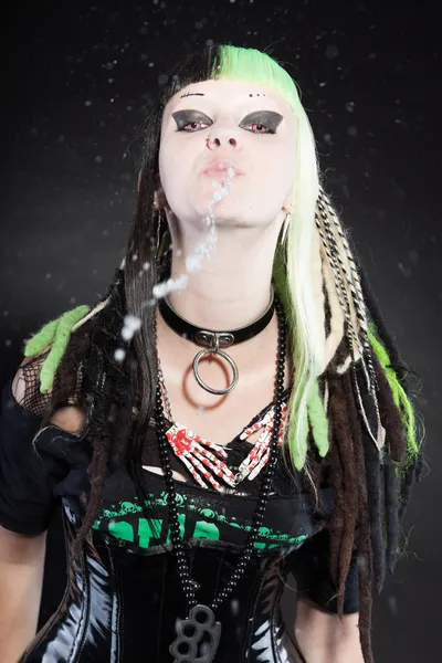 Chica cyber punk con cabello rubio verde y ojos rojos aislados sobre fondo negro. Escupiendo agua. Cara expresiva. Captura de estudio . —  Fotos de Stock