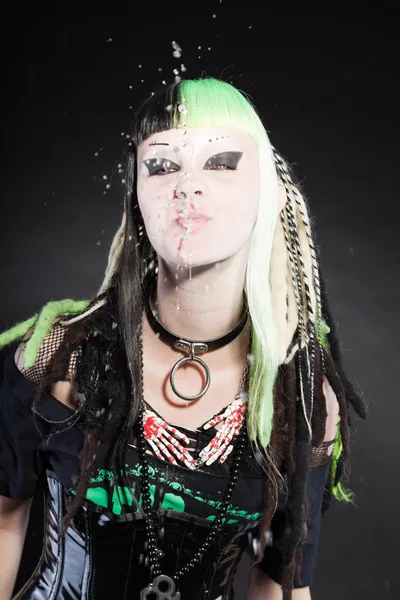 Cyber punk girl with green blond hair and red eyes isolated on black background. Spitting water. Expressive face. Studio shot. — Stock Photo, Image