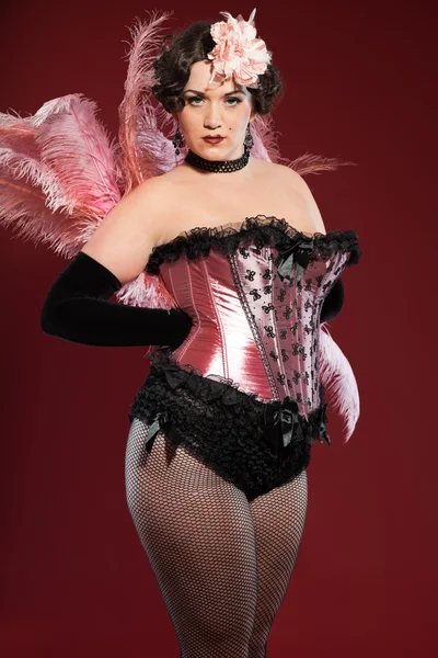 Sexy burlesque pin up mujer con el pelo largo rubio vestido de rosa y negro. Estudio de la moda tiro aislado sobre fondo rojo . —  Fotos de Stock