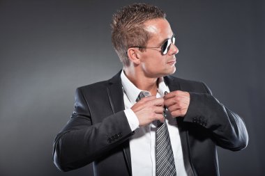 Good looking business man with black sunglasses and short blond hair. Tough guy. Wearing tie and black jacket. clipart