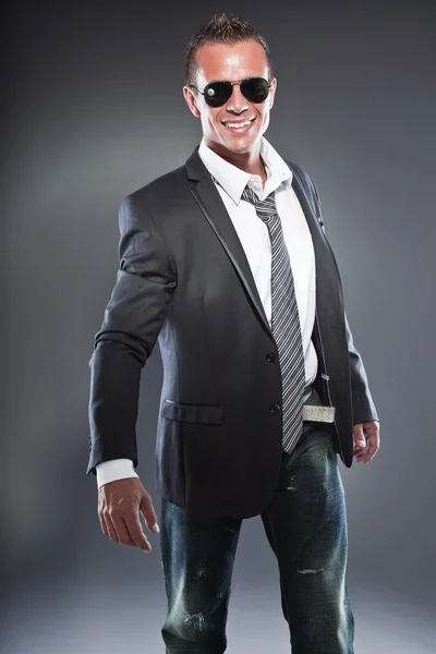 Homem de negócios bonito com óculos de sol pretos e cabelo loiro curto. Um tipo duro. Vestindo gravata e casaco preto . — Fotografia de Stock