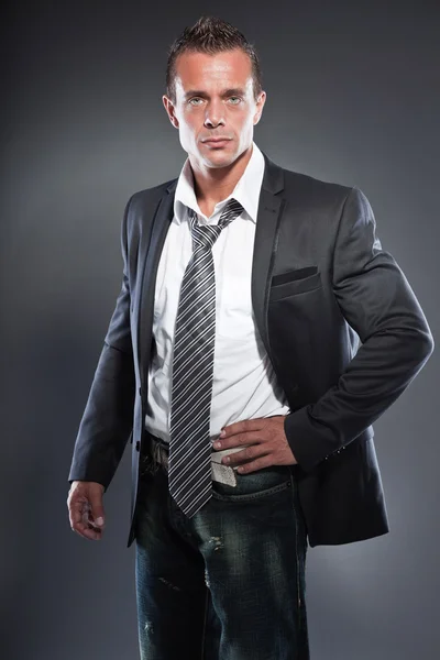 Bonito homem de negócios olhos azuis e cabelo loiro curto. Um tipo duro. Vestindo gravata e casaco preto . — Fotografia de Stock
