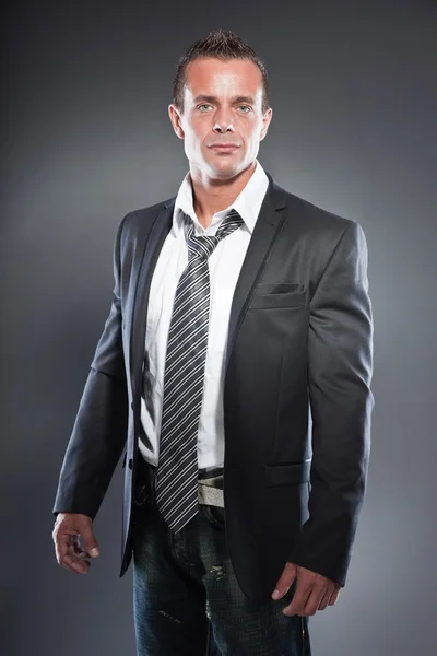 Bonito homem de negócios olhos azuis e cabelo loiro curto. Um tipo duro. Vestindo gravata e casaco preto . — Fotografia de Stock