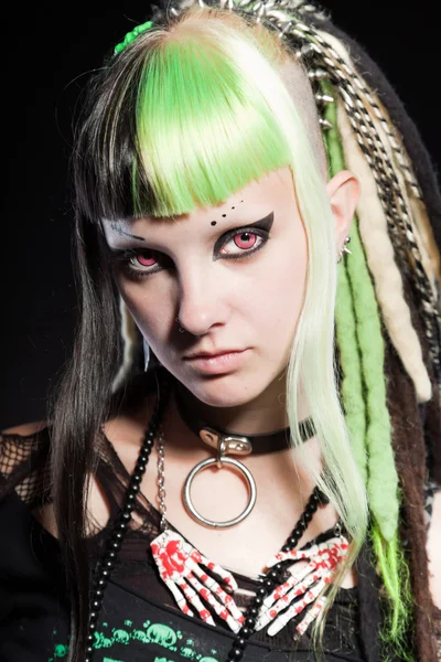 Cyber punk kız yeşil sarı saçları ve siyah arka plan üzerine izole kırmızı gözleri. etkileyici bir yüz. Stüdyo vurdu.