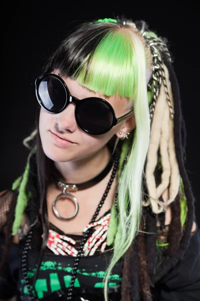 Menina punk cibernético com cabelo loiro verde e olhos vermelhos isolados no fundo preto. A usar óculos escuros. Cara expressiva. Estúdio . — Fotografia de Stock