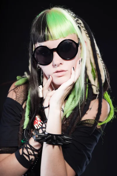Chica cyber punk con cabello rubio verde y ojos rojos aislados sobre fondo negro. Llevando gafas de sol negras. Cara expresiva. Captura de estudio . — Foto de Stock