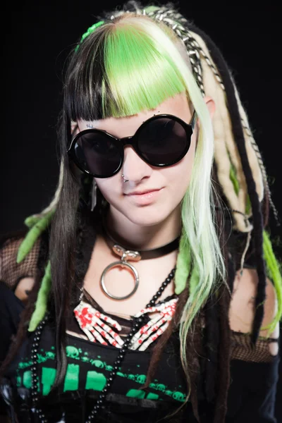 Chica cyber punk con cabello rubio verde y ojos rojos aislados sobre fondo negro. Llevando gafas de sol negras. Cara expresiva. Captura de estudio . —  Fotos de Stock