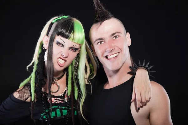 stock image Couple of cyber punk girl with green blond hair and punk man with mohawk haircut. Expressive faces. Isolated on black background. Studio shot.