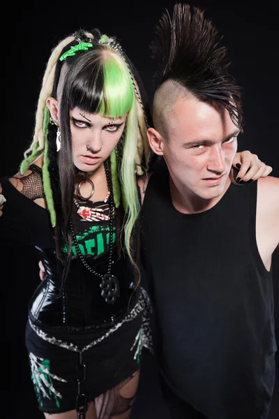 Par cyber punk tjej med gröna blont hår och punk man med mohawk frisyr. uttrycksfulla ansikten. isolerade på svart bakgrund. Studio skott. — Stockfoto
