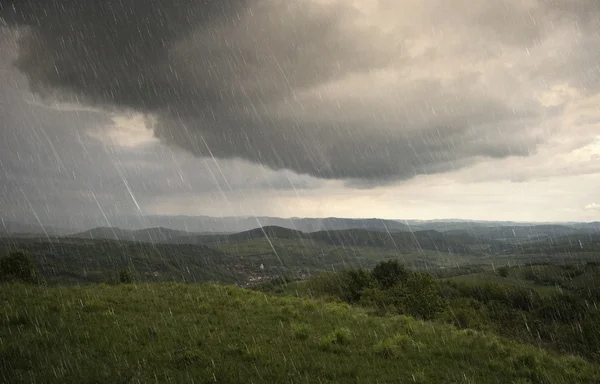 Lanskap dengan hujan dan awan dramatis di atas bukit — Stok Foto