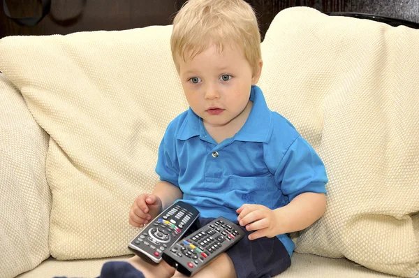 Lindo niño viendo la televisión, sentado en un cha muy cómodo y suave —  Fotos de Stock