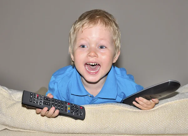 Roztomilé dítě sleduje televizi, sedící v velmi pohodlné a měkké cha — Stock fotografie