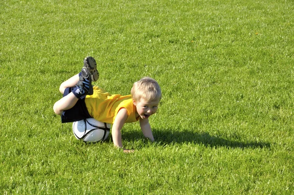 Niño o niño juega fútbol o deportes de fútbol para hacer ejercicio y —  Fotos de Stock