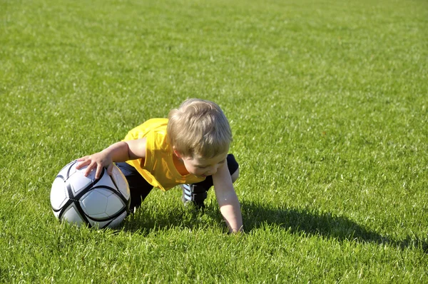 Молодий хлопчик або дитина грає у футбол або футбол для занять спортом — стокове фото