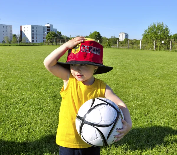 Young boy or kid with German cap plays soccer or football sports — Stock Photo, Image