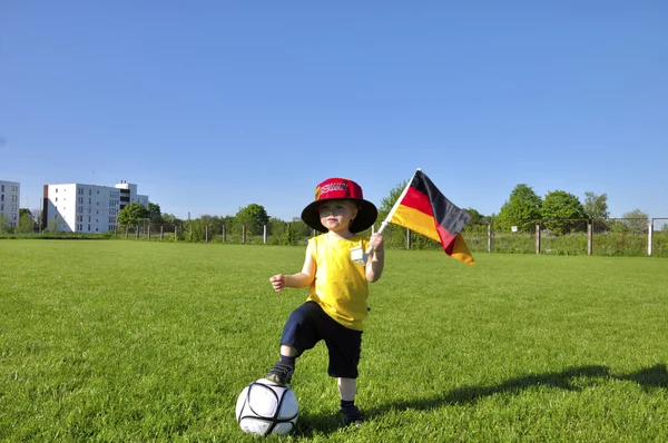 Young boy or kid with German flag and cap plays soccer or footba — Stock Photo, Image
