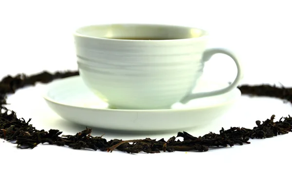 stock image Cup of tea and tea leaves on white background