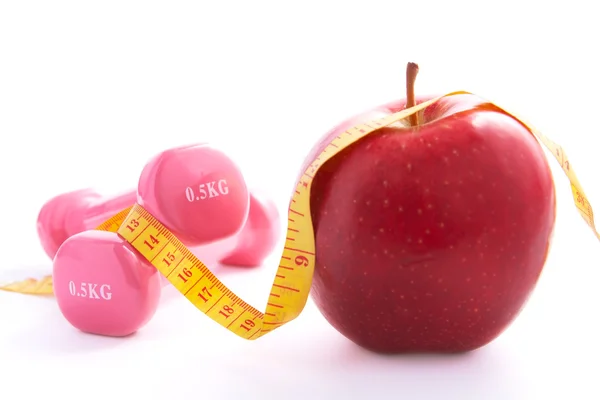 Apple and dumbbells tied with a measuring tape. — Stock Photo, Image