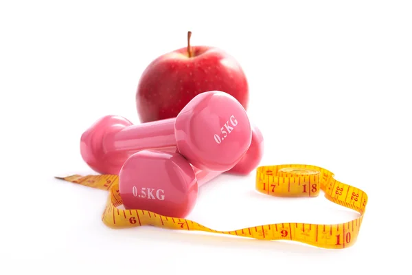Apple and dumbbells with a measuring tape. — Stock Photo, Image