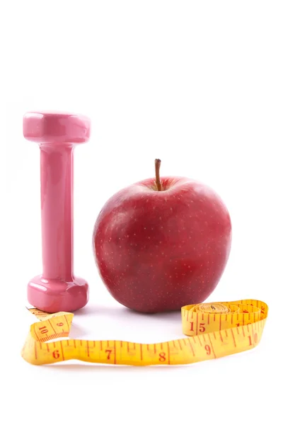 Apple and dumbbells with a measuring tape. — Stock Photo, Image