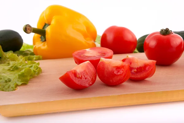 stock image Red tomato cuts with vegetables on board