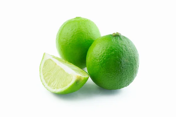 Two green limes and slice — Stock Photo, Image
