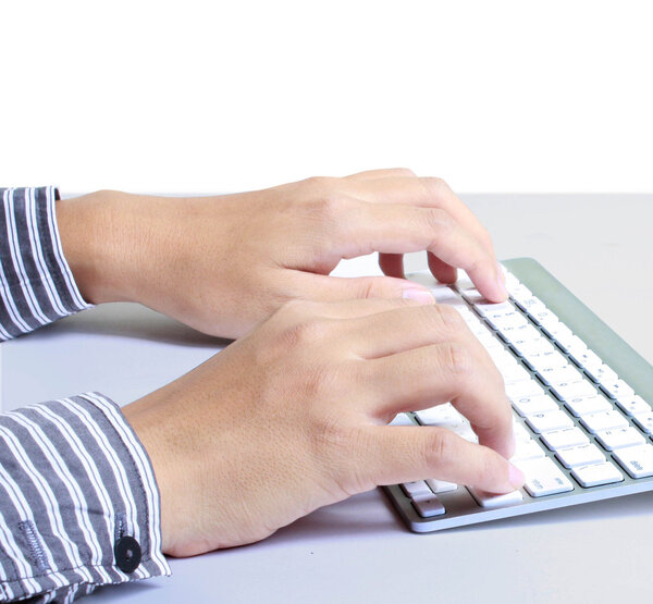 Hands typing on the computer keyboard in an office at a workplace