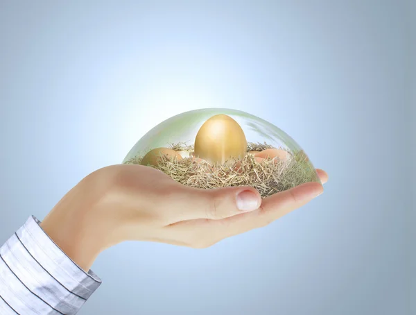 Gouden ei in de hand — Stockfoto