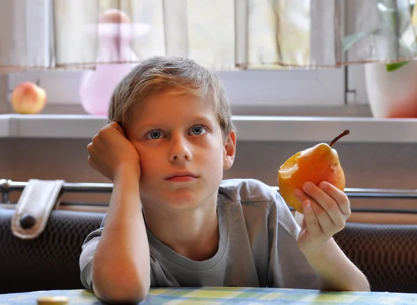 Boy eet een peer — Stockfoto