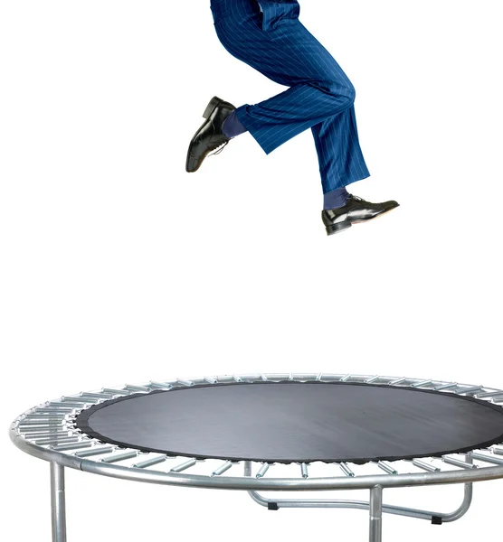 Affärsman som studsar på en trampolin på vit Stockfoto
