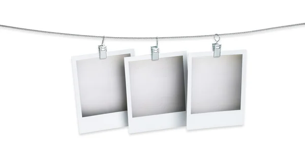 Tre immagini di polaroid bianche appese a un filo isolato su cui — Foto Stock