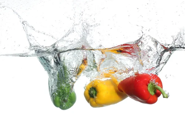 Tre paprika ramla i vattnet, vit bakgrund — Stockfoto
