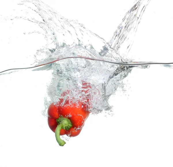 Κόκκινο πιπέρι που πέφτουν στο νερό λευκό φόντο — Φωτογραφία Αρχείου